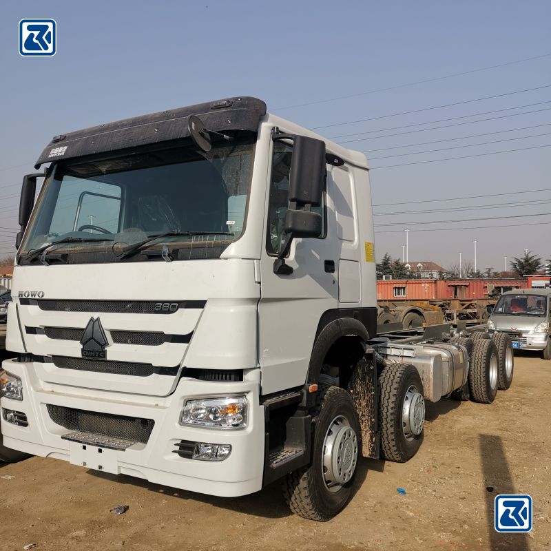 Vista lateral de um camião de carga HOWO 6x6 branco mostrando o perfil do pneu e a cabina do condutor com unidade de ar condicionado no topo.